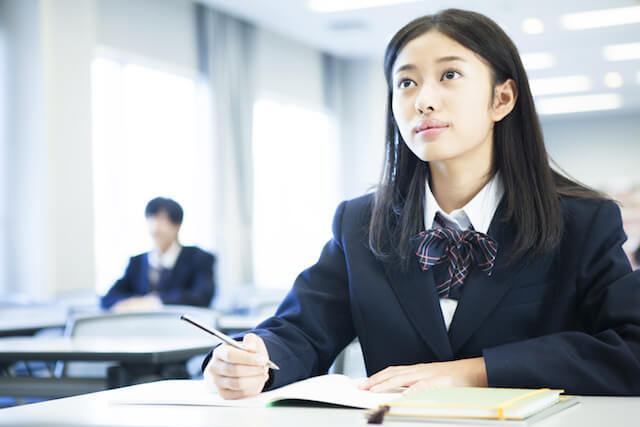 授業を受けながらノートを取る女子生徒